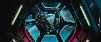 Movie still from “Life” (2017), directed by Daniel Espinosa – Two people in a space station with the earth in the background; Wide shot, Overhead angle