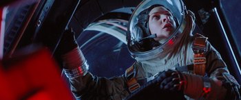 Movie still from “Life” (2017), directed by Daniel Espinosa – A woman in a space suit is holding a drink in her hand; Close Up shot, Low angle