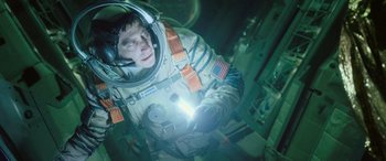 Movie still from “Life” (2017), directed by Daniel Espinosa – A man in a spacesuit is holding a flashlight; Medium shot, Overhead angle