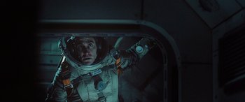 Movie still from “Life” (2017), directed by Daniel Espinosa – A man in a spacesuit in an open doorway; Medium shot, Overhead angle