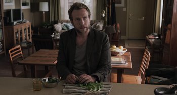 Movie still from “Life of Pi” (2012), directed by Ang Lee – A man sitting at a table with a bowl of vegetables; Medium shot, Over the shoulder angle