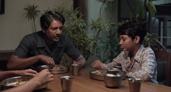 Movie still from “Life of Pi” (2012), directed by Ang Lee – A group of people sitting at a table eating food; Medium shot, High angle