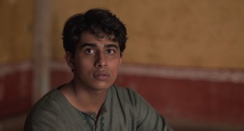 Movie still from “Life of Pi” (2012), directed by Ang Lee – A young man is sitting in front of a wall; Close Up shot, Over the shoulder angle