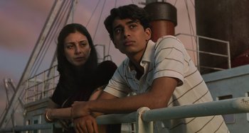Movie still from “Life of Pi” (2012), directed by Ang Lee – A man and a woman sitting next to a railing on a boat; Medium shot, Low angle
