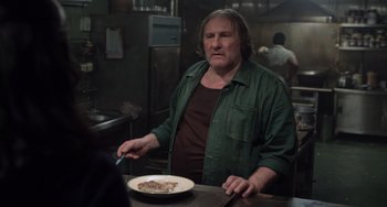 Movie still from “Life of Pi” (2012), directed by Ang Lee – A man standing in front of a plate of food in a kitchen; Medium shot, Over the shoulder angle