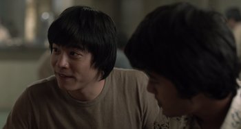 Movie still from “Life of Pi” (2012), directed by Ang Lee – Two young men sitting next to each other in a room; Close Up shot, Over the shoulder angle