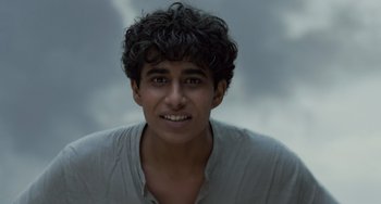 Movie still from “Life of Pi” (2012), directed by Ang Lee – A young man with curly hair and a white shirt; Close Up shot, Low angle
