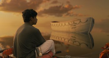 Movie still from “Life of Pi” (2012), directed by Ang Lee – A man sitting in a boat on a body of water; Wide shot, Low angle