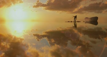 Movie still from “Life of Pi” (2012), directed by Ang Lee – A person standing on a surfboard in the water at sunset; Extreme Wide shot, Low angle