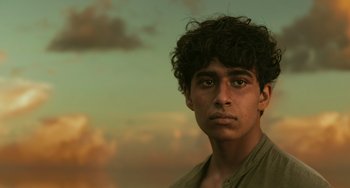 Movie still from “Life of Pi” (2012), directed by Ang Lee – A young man is looking into the distance; Close Up shot, Low angle