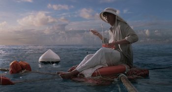 Movie still from “Life of Pi” (2012), directed by Ang Lee – A man sitting on a raft in the middle of the ocean; Wide shot, Low angle