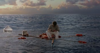 Movie still from “Life of Pi” (2012), directed by Ang Lee – A man sitting on a raft in the middle of the ocean; Wide shot, High angle