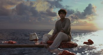 Movie still from “Life of Pi” (2012), directed by Ang Lee – A man sitting on top of a raft in the ocean; Wide shot, Low angle