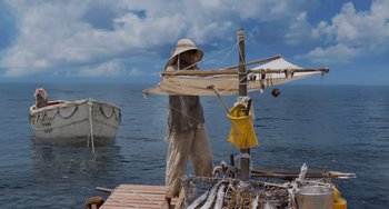 Movie still from “Life of Pi” (2012), directed by Ang Lee – A man standing on top of a dock near the ocean; Wide shot, High angle