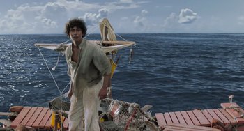 Movie still from “Life of Pi” (2012), directed by Ang Lee – A man standing on the deck of a boat in the ocean; Wide shot, Low angle