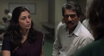 Movie still from “Life of Pi” (2012), directed by Ang Lee – A man and a woman sitting next to each other in a room; Medium shot, Low angle