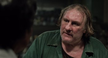 Movie still from “Life of Pi” (2012), directed by Ang Lee – An older man wearing a green shirt looking to his left; Close Up shot, Over the shoulder angle