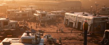 Movie still from “Lightyear” (2022), directed by Angus MacLane – A group of people standing next to a group of rvs in the dirt; Extreme Wide shot, High angle