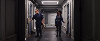Movie still from “Lightyear” (2022), directed by Angus MacLane – A man and a woman are standing in a hallway; Medium shot, Low angle