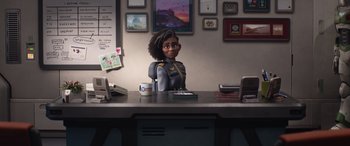 Movie still from “Lightyear” (2022), directed by Angus MacLane – A woman sitting at a desk in front of a phone; Medium shot, Over the shoulder angle