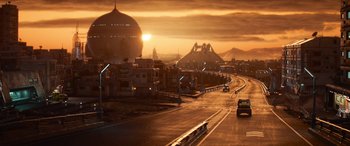 Movie still from “Lightyear” (2022), directed by Angus MacLane – Cars driving down a street at sunset with buildings in the background; Extreme Wide shot, High angle
