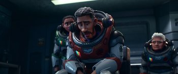 Movie still from “Lightyear” (2022), directed by Angus MacLane – A couple of people that are sitting down in a room; Medium shot, Over the shoulder angle