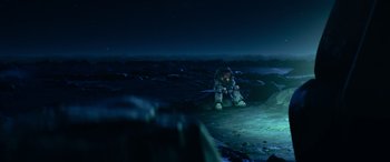 Movie still from “Lightyear” (2022), directed by Angus MacLane – A person sitting on the ground at night in the dark; Extreme Wide shot, High angle