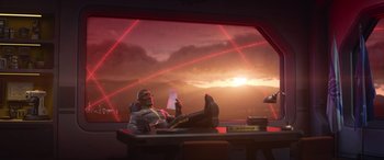 Movie still from “Lightyear” (2022), directed by Angus MacLane – A man sitting at a desk in front of a sunset; Wide shot, Low angle