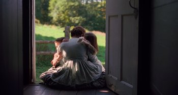 Movie still from “Little Women” (2019), directed by Greta Gerwig – A woman and two children sitting on the porch of a house; Wide shot, Over the shoulder angle