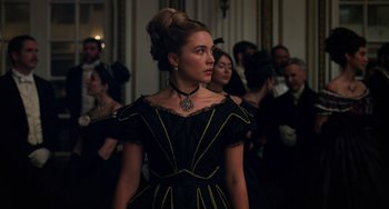 Movie still from “Little Women” (2019), directed by Greta Gerwig – A woman in a black dress standing in front of a group of people; Medium shot, Low angle
