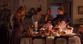 Movie still from “Little Women” (2019), directed by Greta Gerwig – A group of people standing around a table filled with food; Medium shot, High angle