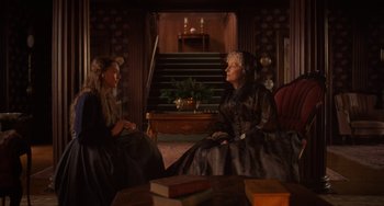 Movie still from “Little Women” (2019), directed by Greta Gerwig – Two women sitting on a couch in a room; Medium shot, Over the shoulder angle