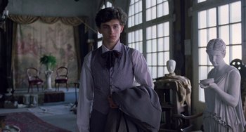 Movie still from “Little Women” (2019), directed by Greta Gerwig – A man in a suit and tie holding a bag; Medium shot, Low angle