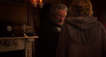Movie still from “Little Women” (2019), directed by Greta Gerwig – An older man standing in front of a fireplace; Medium shot, Over the shoulder angle