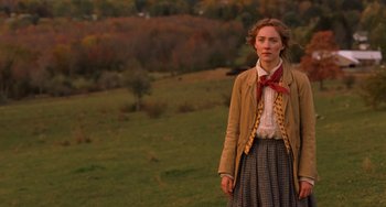Movie still from “Little Women” (2019), directed by Greta Gerwig – A woman standing in a field wearing a bow tie; Medium shot, Over the shoulder angle