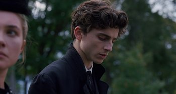 Movie still from “Little Women” (2019), directed by Greta Gerwig – A young man in a black jacket is looking down at his face; Close Up shot, Low angle