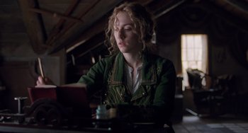 Movie still from “Little Women” (2019), directed by Greta Gerwig – A woman sitting at a table looking at a tablet; Medium shot, Low angle