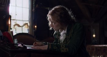 Movie still from “Little Women” (2019), directed by Greta Gerwig – A person sitting at a table writing on a piece of paper; Medium shot, Low angle