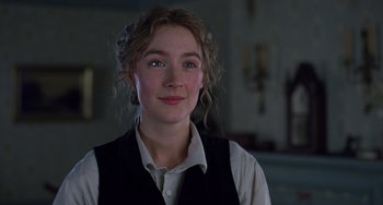 Movie still from “Little Women” (2019), directed by Greta Gerwig – A young woman in a white shirt and black vest; Close Up shot, Over the shoulder angle