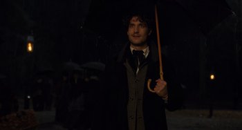 Movie still from “Little Women” (2019), directed by Greta Gerwig – A man holding an umbrella in the dark; Close Up shot, Over the shoulder angle