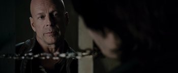 Movie still from “Live Free or Die Hard” (2007), directed by Len Wiseman – A man with a chain around his neck is looking into the mirror; Close Up shot, Over the shoulder angle