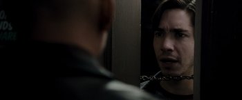 Movie still from “Live Free or Die Hard” (2007), directed by Len Wiseman – A man with a chain around his neck looking at himself in the mirror; Close Up shot, Over the shoulder angle