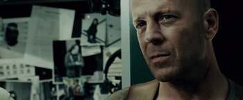 Movie still from “Live Free or Die Hard” (2007), directed by Len Wiseman – A man's face in front of pictures; Close Up shot, Low angle