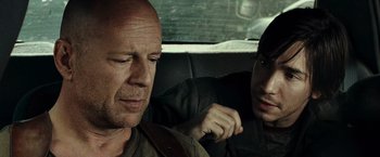 Movie still from “Live Free or Die Hard” (2007), directed by Len Wiseman – Two men sitting in the back seat of a car; Close Up shot, Over the shoulder angle