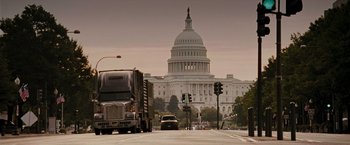 Movie still from “Live Free or Die Hard” (2007), directed by Len Wiseman – A truck driving down a street past a building; Extreme Wide shot, Low angle