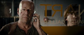 Movie still from “Live Free or Die Hard” (2007), directed by Len Wiseman – A bald man is talking on a cell phone; Close Up shot, Low angle
