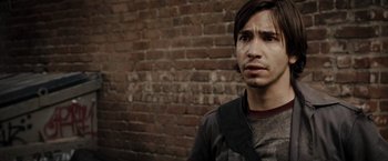Movie still from “Live Free or Die Hard” (2007), directed by Len Wiseman – A man standing in front of a brick wall; Close Up shot, Over the shoulder angle