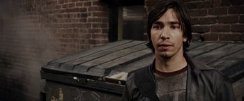 Movie still from “Live Free or Die Hard” (2007), directed by Len Wiseman – A man standing in front of a brick building; Close Up shot, Over the shoulder angle