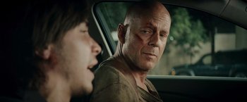Movie still from “Live Free or Die Hard” (2007), directed by Len Wiseman – A man and a woman sitting in a car looking at each other; Close Up shot, Over the shoulder angle