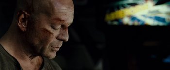Movie still from “Live Free or Die Hard” (2007), directed by Len Wiseman – A bald man with bruises on his face; Close Up shot, Over the shoulder angle